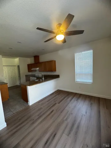 a kitchen with kitchen island wooden floors appliances and cabinets