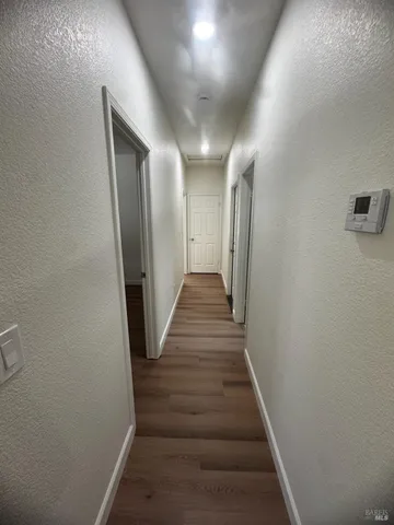 a view of a hallway with wooden floor and staircase