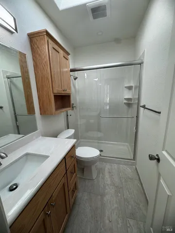 a bathroom with a sink a toilet and shower