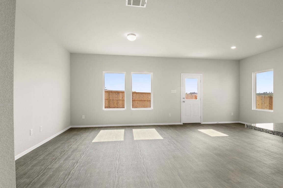 5409 Murano Cove Austin, TX 78747 - Photo 8 of 32 an empty room with wooden floor and windows
