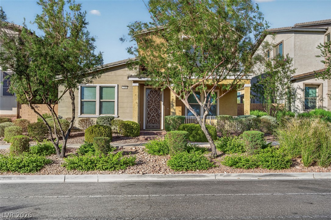1100 East Sunset Road Henderson, NV 89011 - Photo 2 of 58 A welcoming facade, framed by lush green landscaping, offers charming curb appeal.