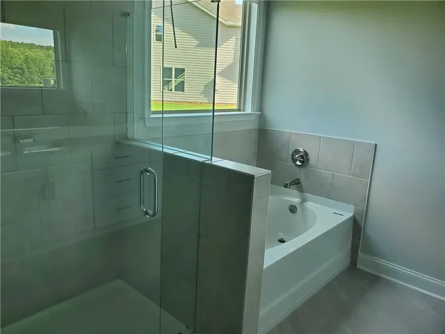 a bathroom with a tub sink and mirror