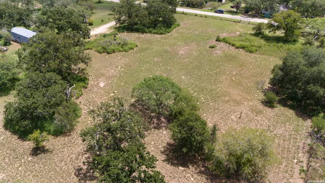 an aerial view of ocean with green space