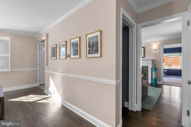 a view of a hallway with wooden floor and a living room