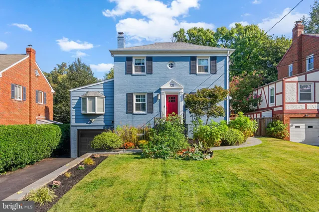 a front view of a house with yard and green space