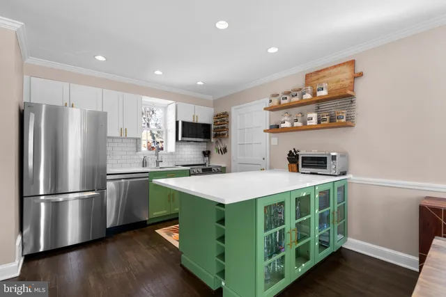 a kitchen with kitchen island stainless steel appliances a sink stove and refrigerator
