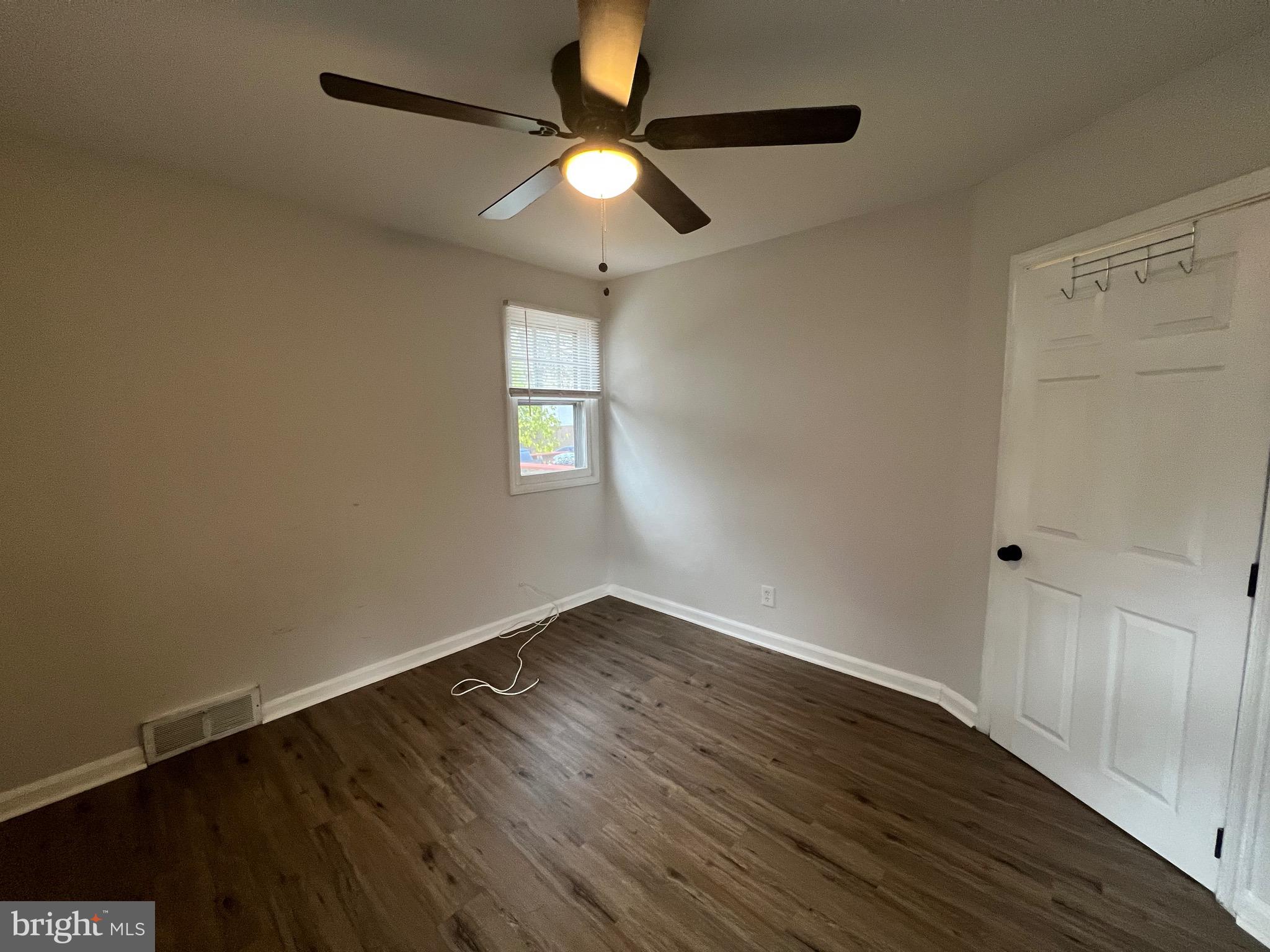213 Nicholson Road West Collingswood Heights, NJ 08059 - Photo 7 of 18 an empty room with wooden floor fan and windows