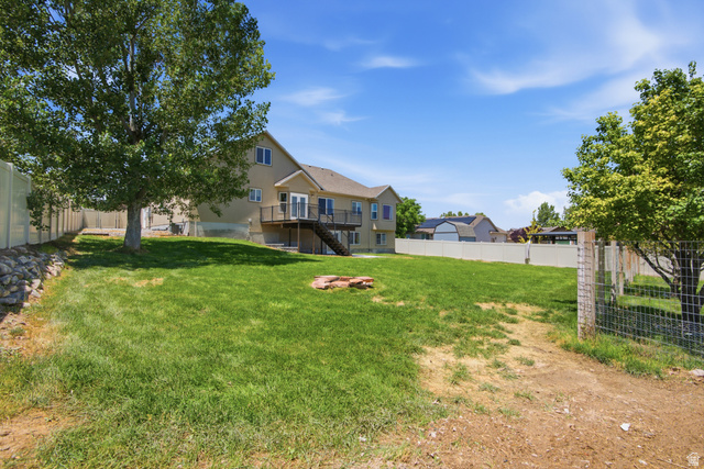 1252 Skyline Road Saratoga Springs, UT 84045 - Photo 46 of 51 Expansive backyard with a manicured lawn, established trees, and perimeter fencing
