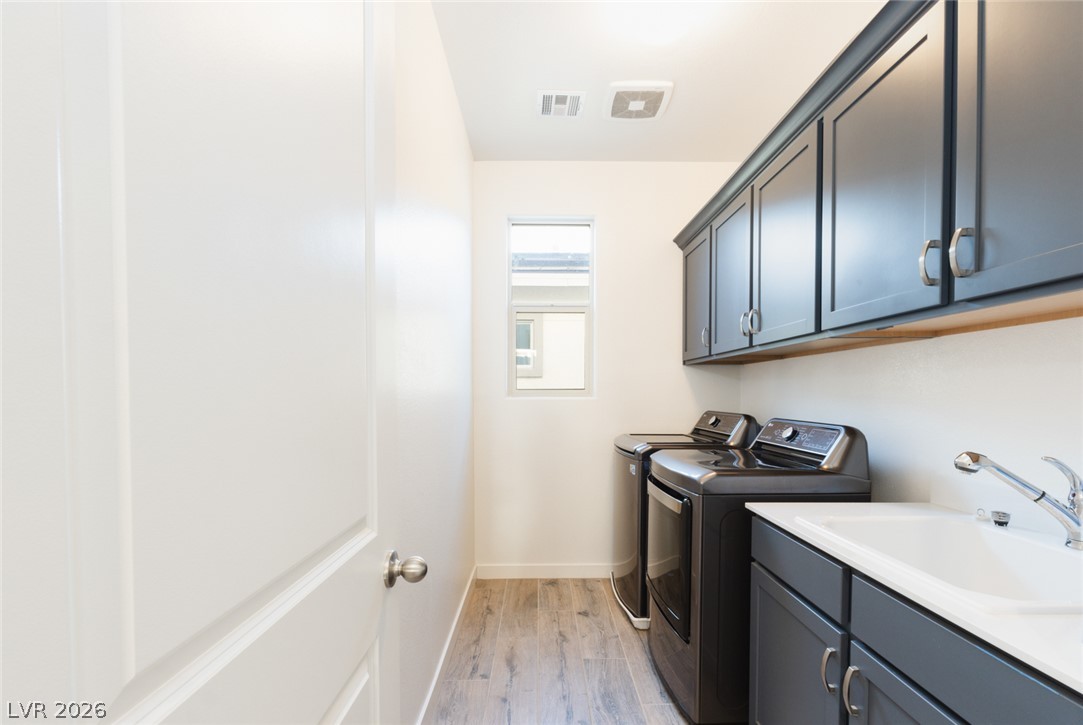920 East Sunset Road Henderson, NV 89011 - Photo 19 of 33 Functional laundry space featuring modern appliances, ample cabinetry, and a utility sink for daily convenience.