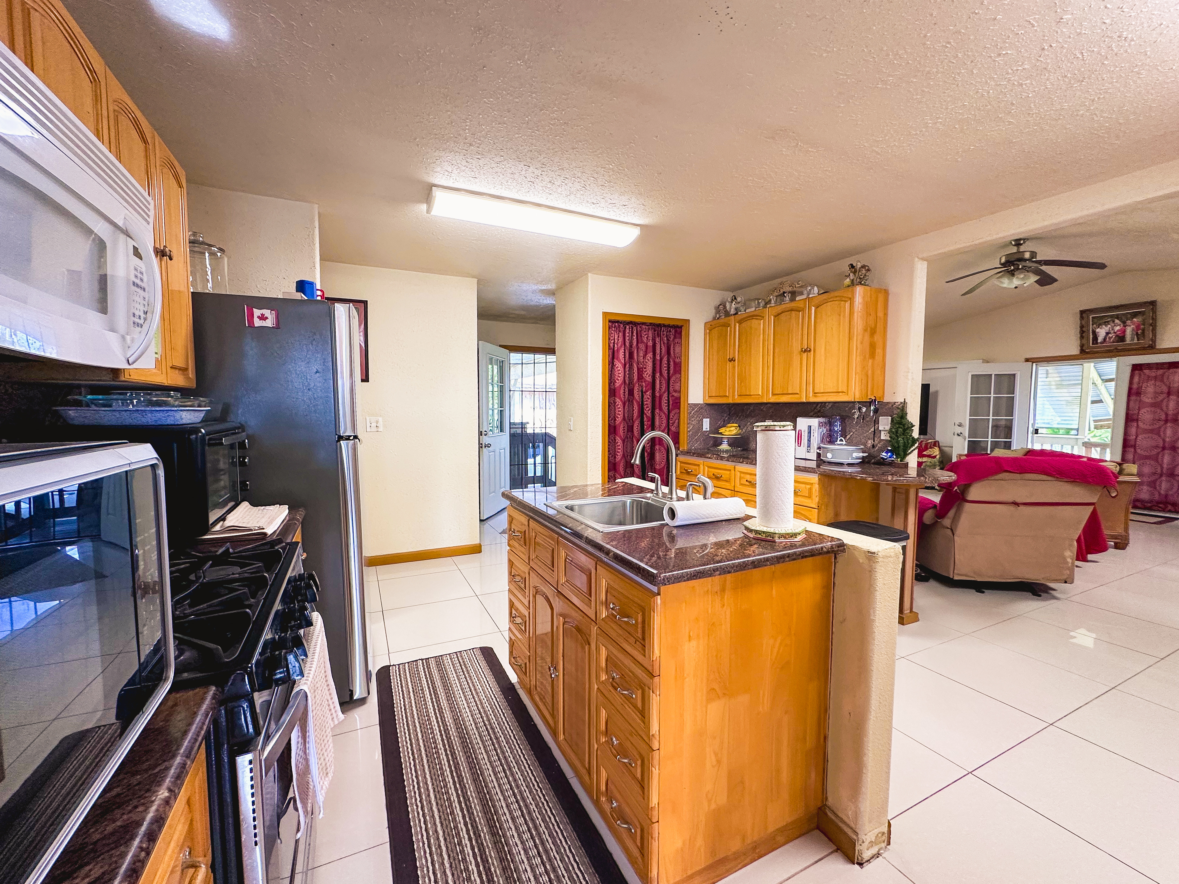 18-7747 North Kulani Road Mountain View, HI 96771 - Photo 19 of 28 a kitchen that has a lot of cabinets stainless steel appliances and a counter top space