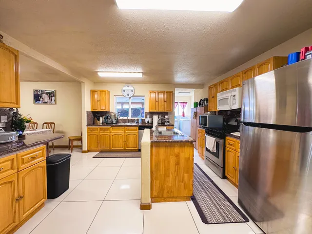 a kitchen with stainless steel appliances granite countertop a refrigerator and a stove top oven
