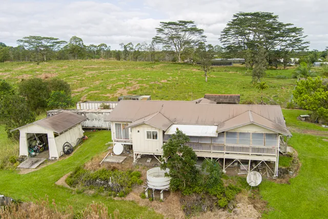 an aerial view of a house with a garden and lake view