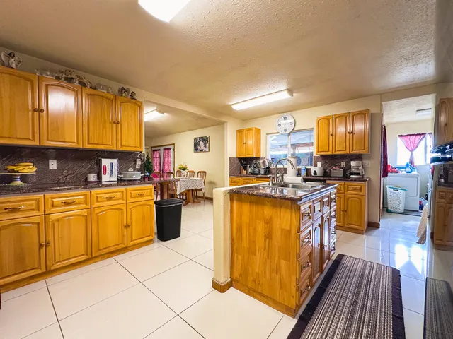 a kitchen with stainless steel appliances granite countertop wooden cabinets a stove top oven a sink and dishwasher