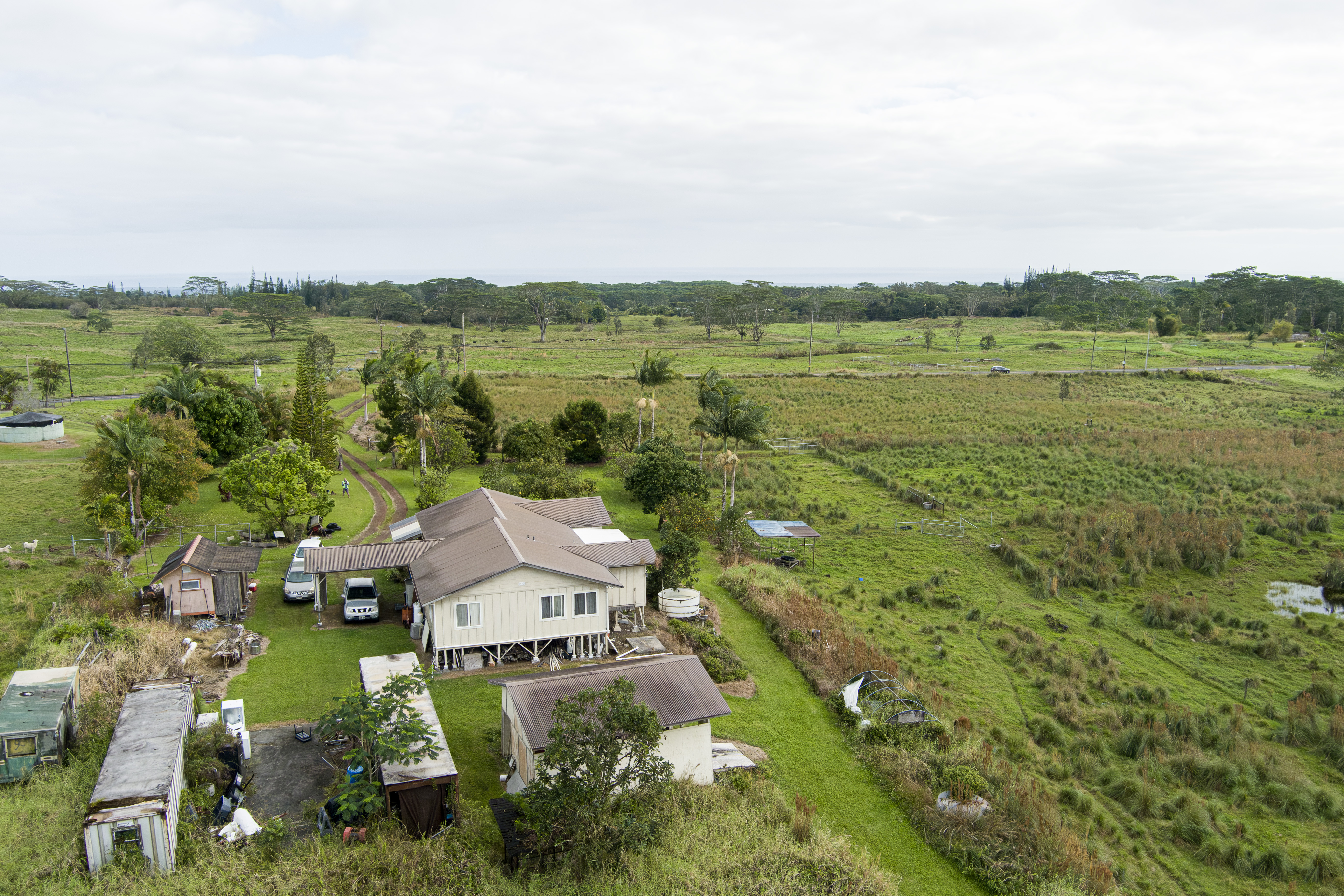18-7747 North Kulani Road Mountain View, HI 96771 - Photo 4 of 28 an aerial view of a house with green landscape and water view