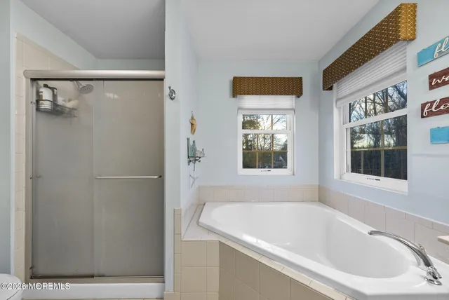 a white bath tub sitting next to a shower