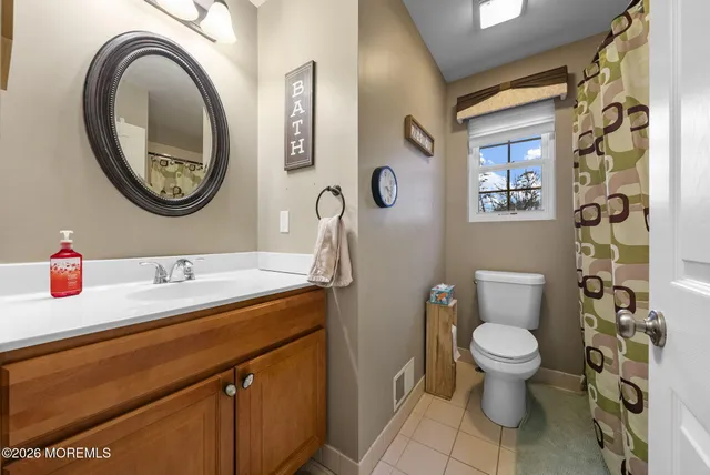 a bathroom with a toilet a sink and a mirror