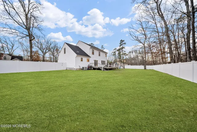 a view of yard with green space and wooden fence