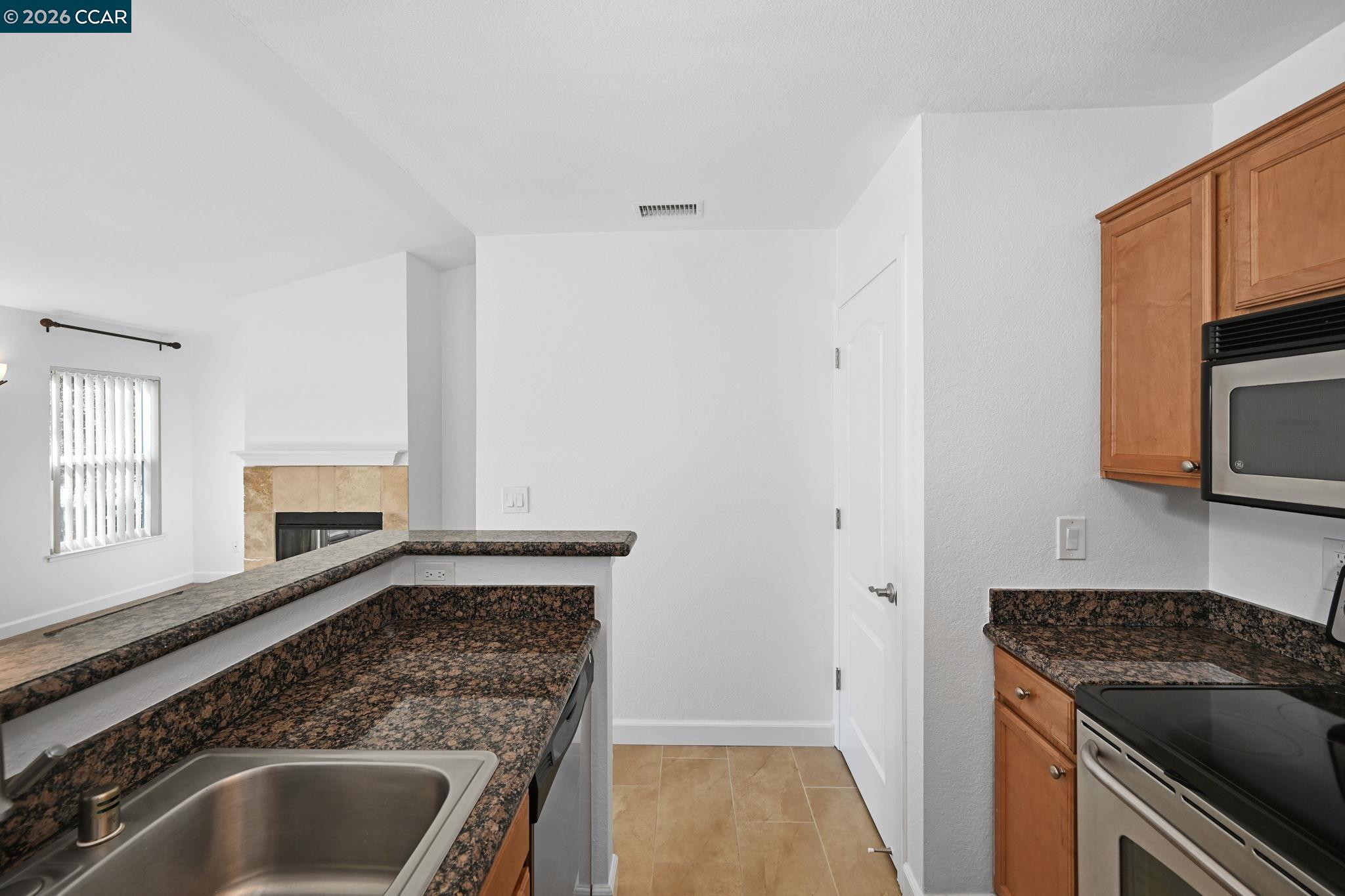 140 Reflections Drive, Unit 21 San Ramon, CA 94583 - Photo 12 of 34 a kitchen with granite countertop a sink stove and cabinets