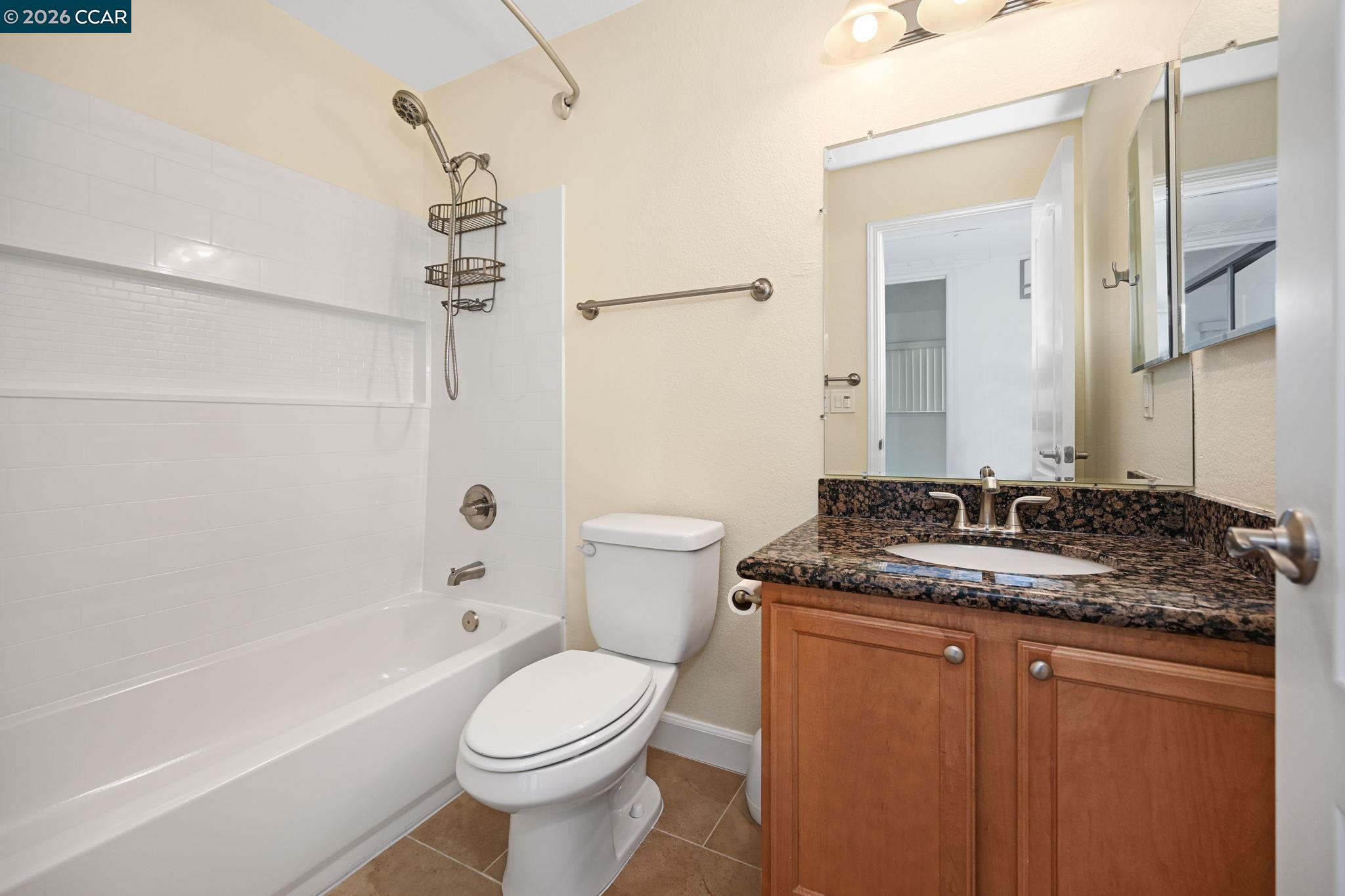 140 Reflections Drive, Unit 21 San Ramon, CA 94583 - Photo 19 of 34 a bathroom with a granite countertop sink a toilet a mirror and bathtub