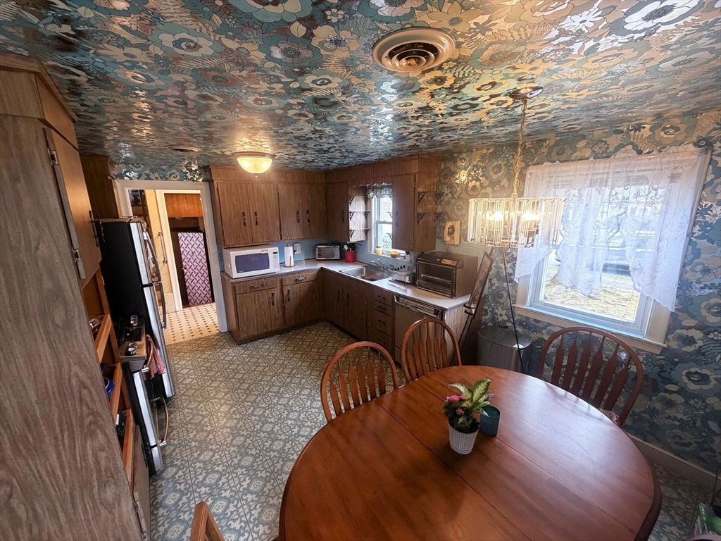 53 Yale Road Needham, MA 02494 - Photo 14 of 21 a kitchen with stainless steel appliances granite countertop a sink a stove a dining table and chairs