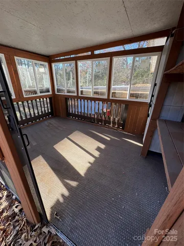 a view of an empty room with wooden floor and windows