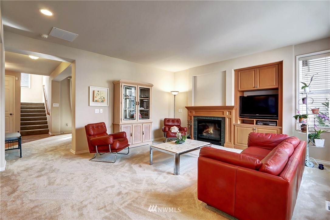 17013 Parkside Way Southeast Renton, WA 98058 - Photo 10 of 26 a living room with furniture a flat screen tv and a fireplace