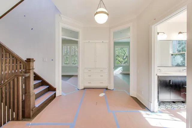 a view of hallway with stairs and wooden floor