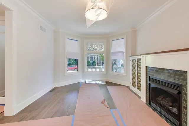 an empty room with windows and fireplace