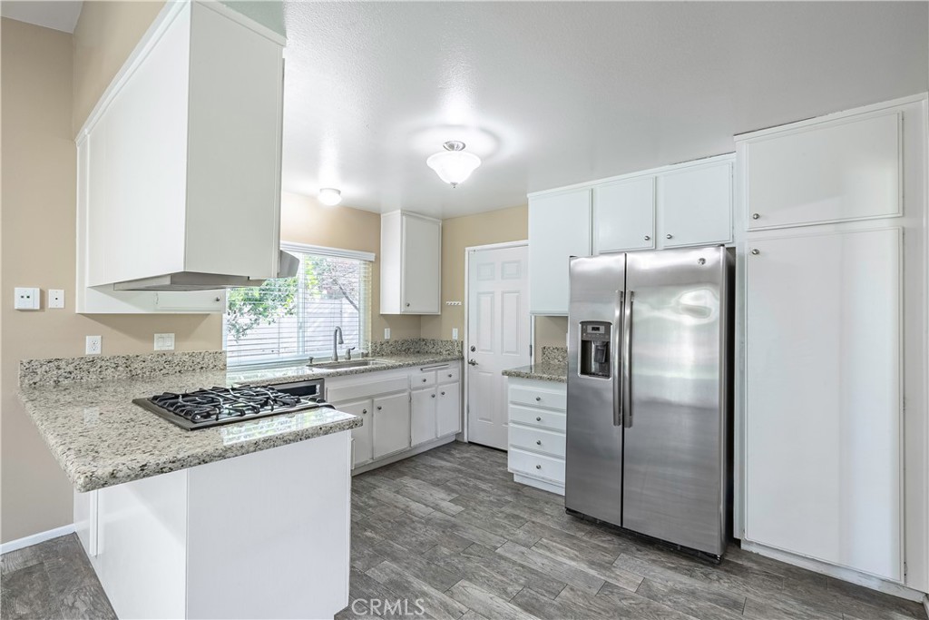 2415 Peppertree Lane Riverside, CA 92506 - Photo 6 of 39 a kitchen with stainless steel appliances granite countertop a refrigerator stove sink and cabinets