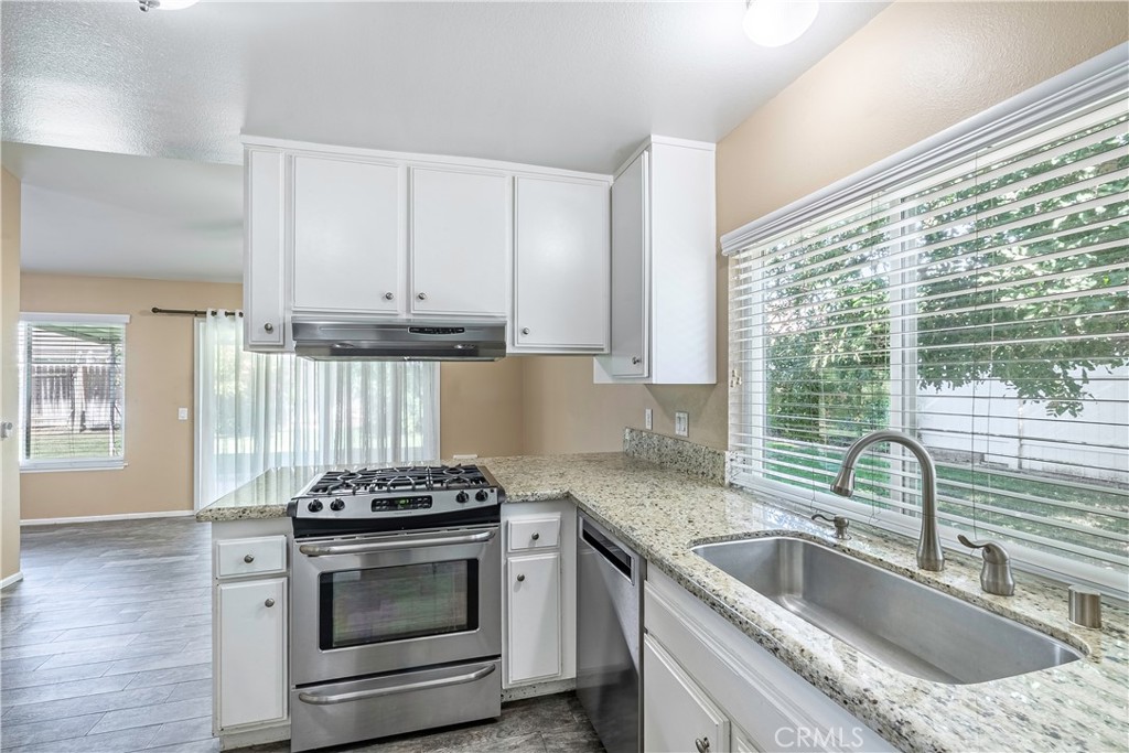 2415 Peppertree Lane Riverside, CA 92506 - Photo 7 of 39 a kitchen with granite countertop a sink stove and cabinets