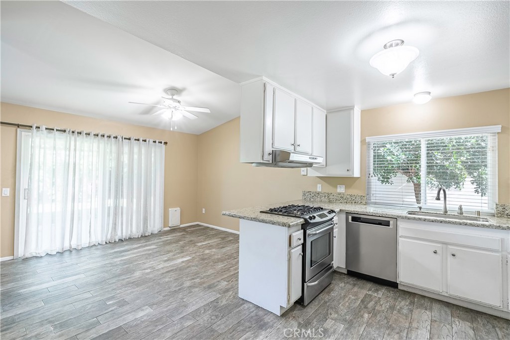 2415 Peppertree Lane Riverside, CA 92506 - Photo 8 of 39 a kitchen with a stove a sink and wooden floor