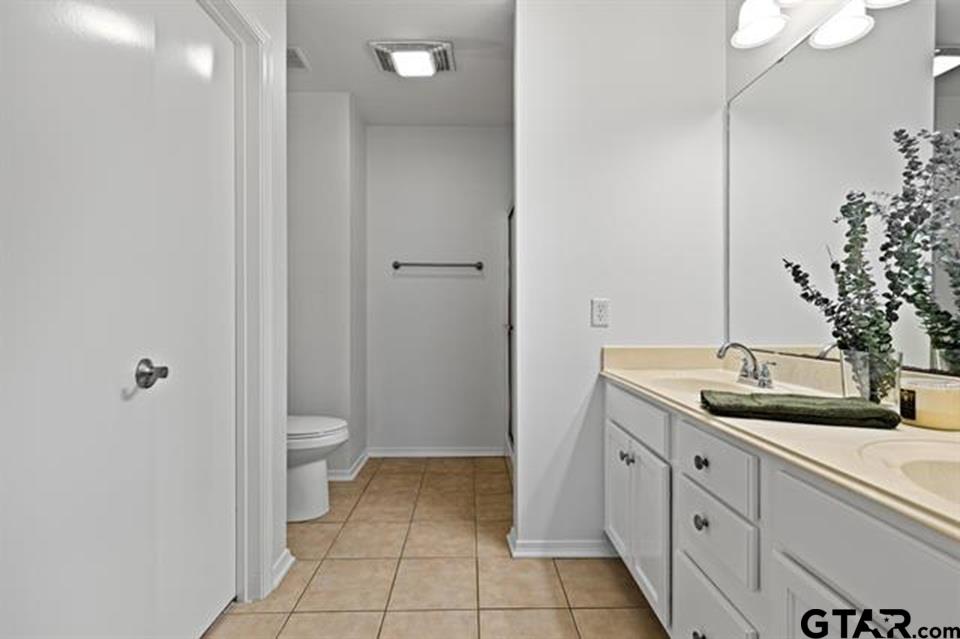 1807 Paverstone Lane Longview, TX 75605 - Photo 26 of 37 a spacious bathroom with a granite countertop sink a toilet and mirror