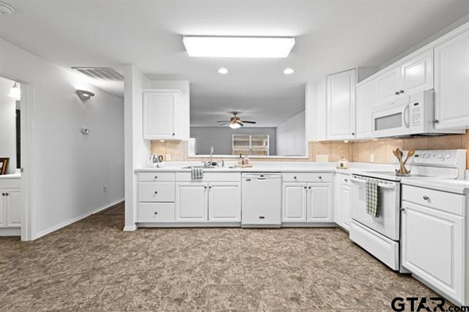 1807 Paverstone Lane Longview, TX 75605 - Photo 7 of 37 a kitchen with white cabinets and white appliances