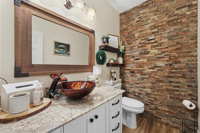 a bathroom with a granite countertop toilet and a sink