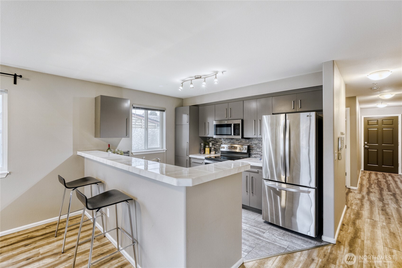 10511 Midvale Avenue North, Unit 302 Seattle, WA 98133 - Photo 7 of 24 a kitchen with stainless steel appliances a refrigerator sink and stove
