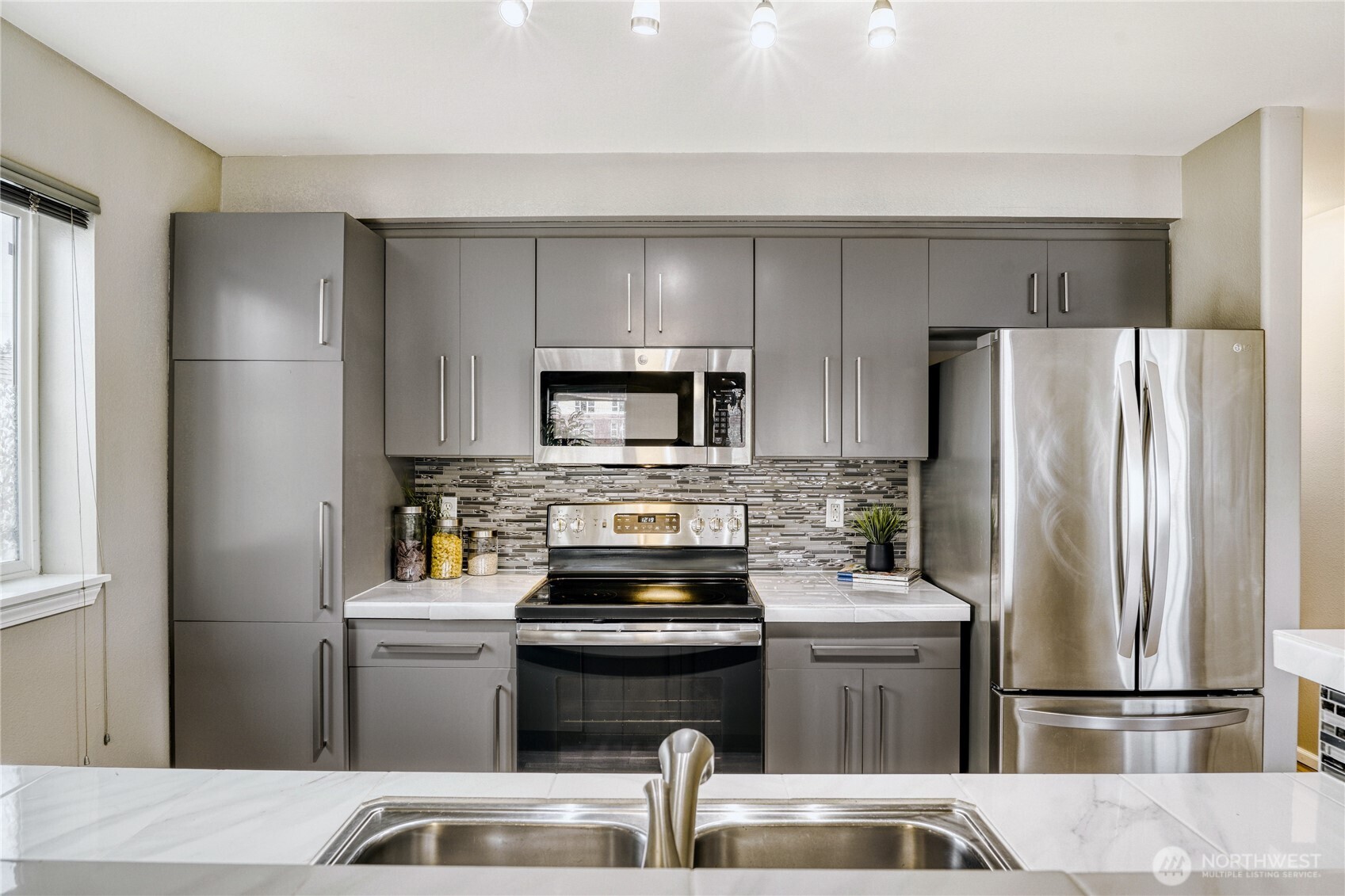 10511 Midvale Avenue North, Unit 302 Seattle, WA 98133 - Photo 9 of 24 a kitchen with a refrigerator sink and stove
