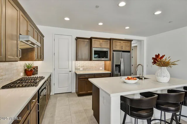 a kitchen with stainless steel appliances kitchen island granite countertop a sink and cabinets