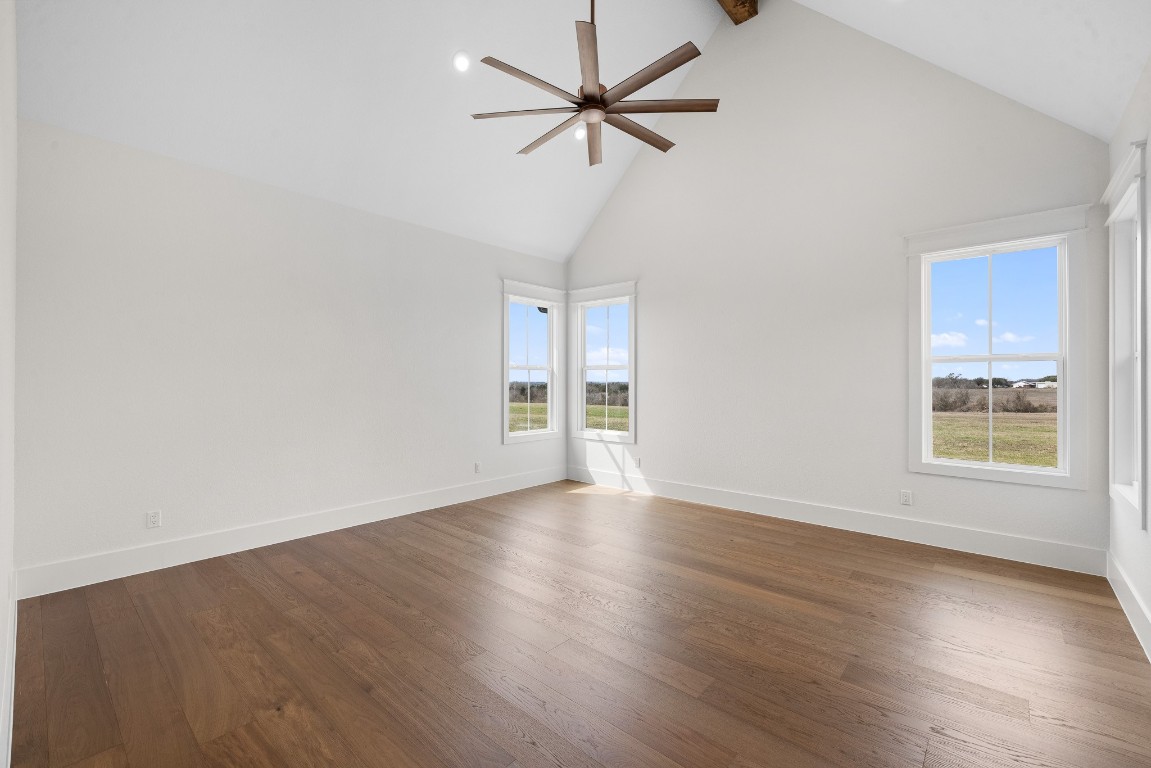 424 Pleasant Hill School Road Brenham, TX 77833 - Photo 19 of 26 an empty room with wooden floor fan and windows