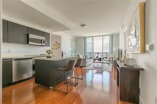 a living room with furniture a flat screen tv and wooden floor