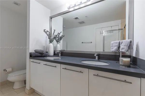 a bathroom with a granite countertop sink a toilet and a mirror