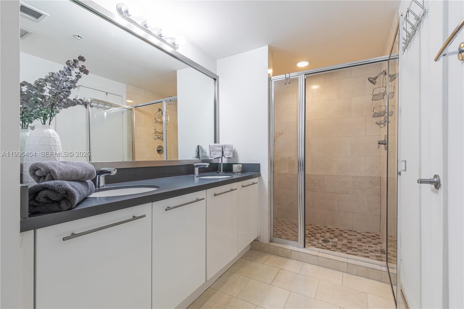 90 Southwest 3rd Street, Unit 3806 Miami, FL 33130 - Photo 14 of 32 a bathroom with a double vanity sink and mirror