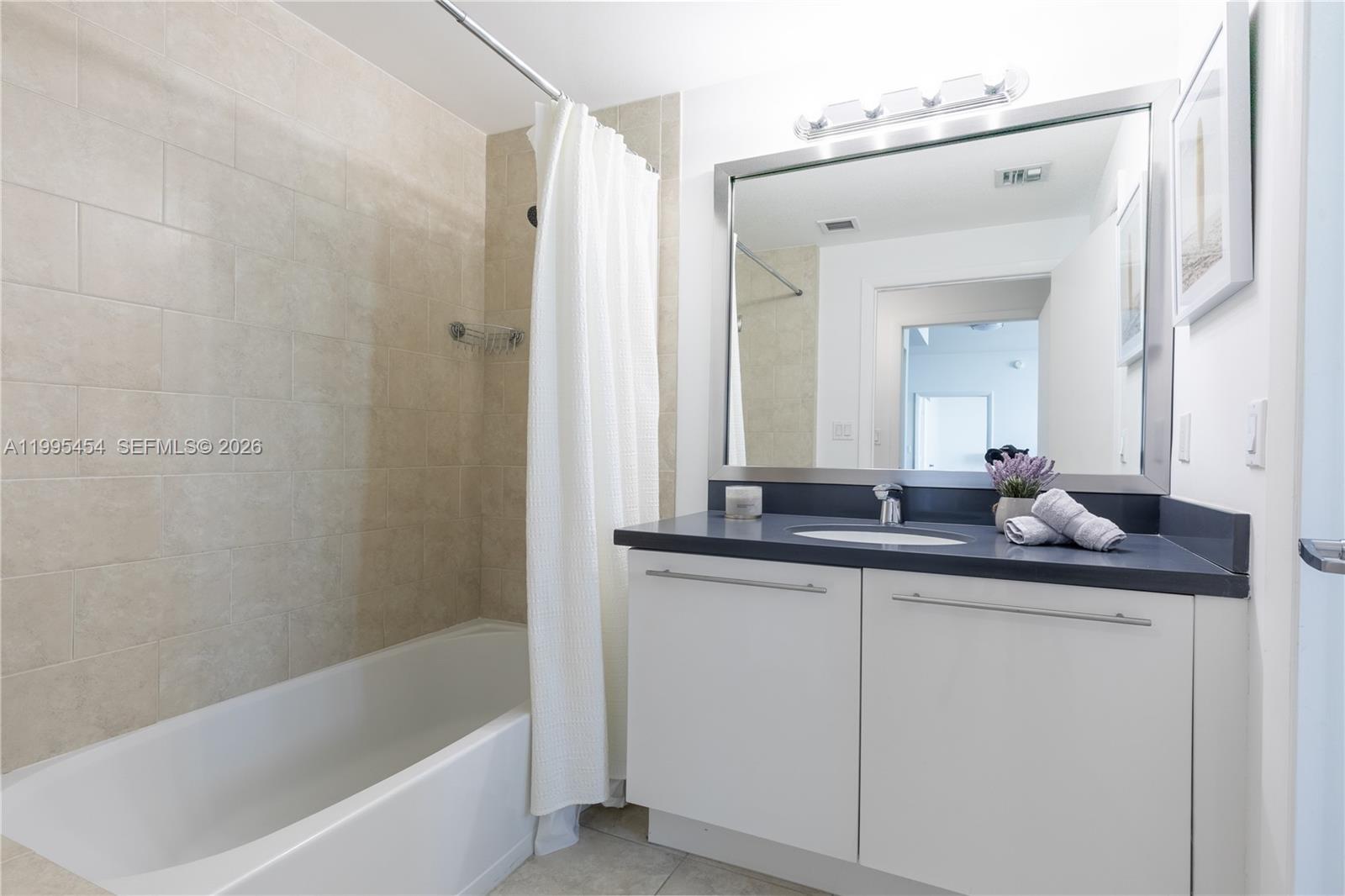 90 Southwest 3rd Street, Unit 3806 Miami, FL 33130 - Photo 16 of 32 a bath room with a sink and a mirror