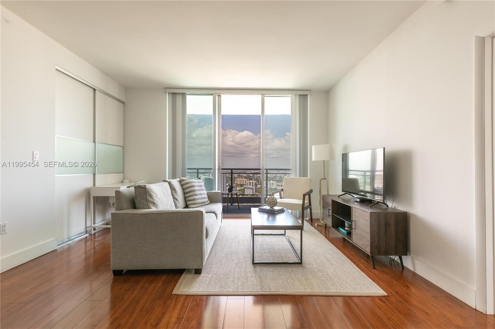 90 Southwest 3rd Street, Unit 3806 Miami, FL 33130 - Photo 5 of 32 a living room with furniture wooden floor and a large window