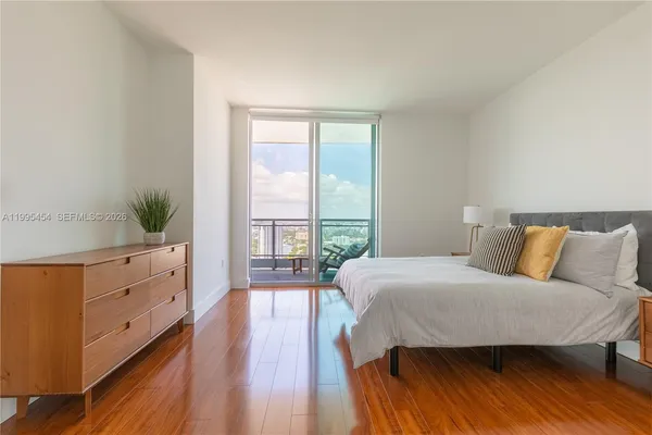 a bedroom with a bed and a large window