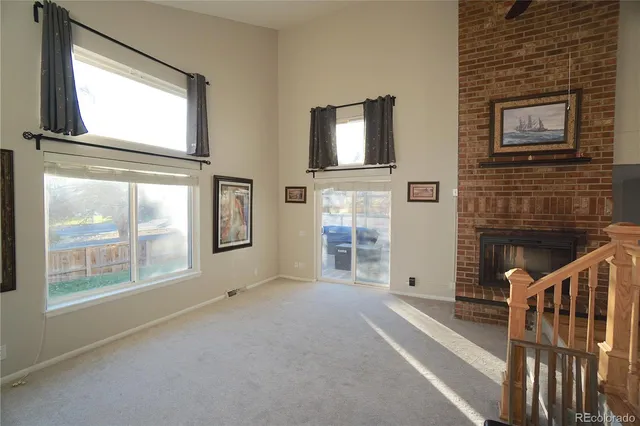 a view of an empty room with brick walls and windows