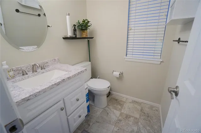 a bathroom with a granite countertop sink toilet and a mirror