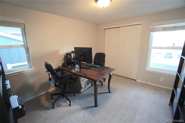 a view of a workspace with furniture and a window