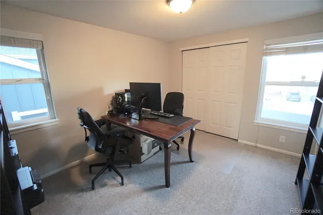 a view of a workspace with furniture and a window