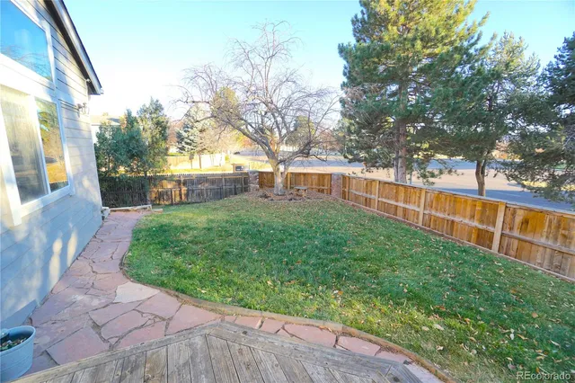 a view of backyard with table and chairs and wooden fence