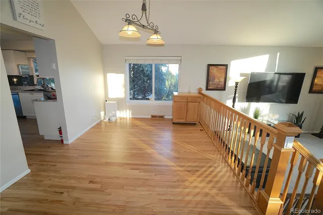 a view of a livingroom with furniture wooden floor windows and a chandelier